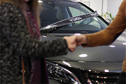 Un commercial sert la main d'un client devant une voiture vendue pendant les Black Friday Auto