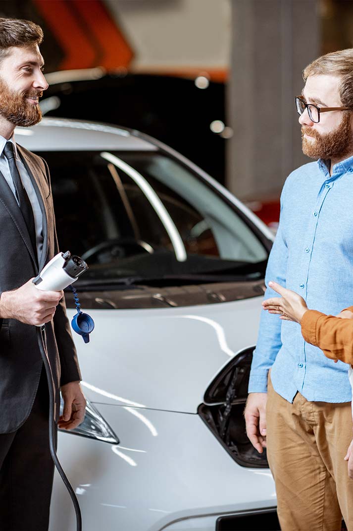 Des clients sont en discussion avec un vendeur de concession