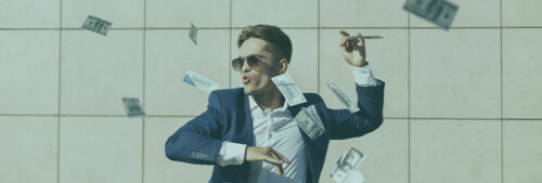 Un homme en costume danse sous une pluie de billets