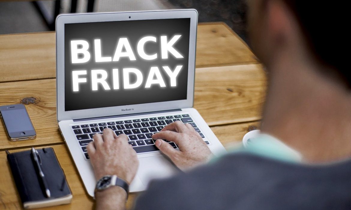 Un homme travaille sur son ordinateur portable et une interface Black Friday