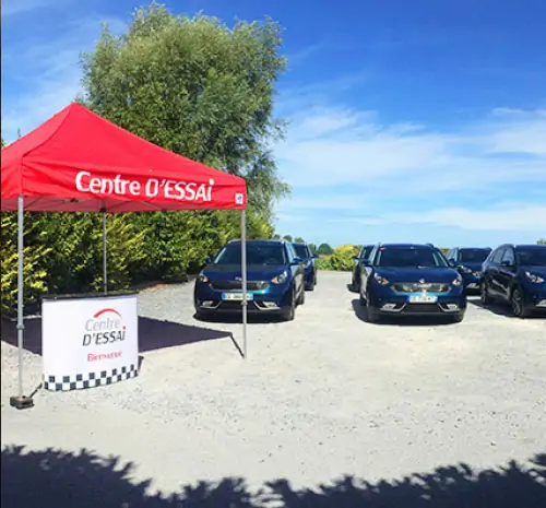 Des véhicules stationnés devant le stand d'accueil Centre d'Essai Driving