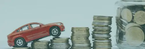 Une voiture miniature positionné sur des piles de pièces de monnaie